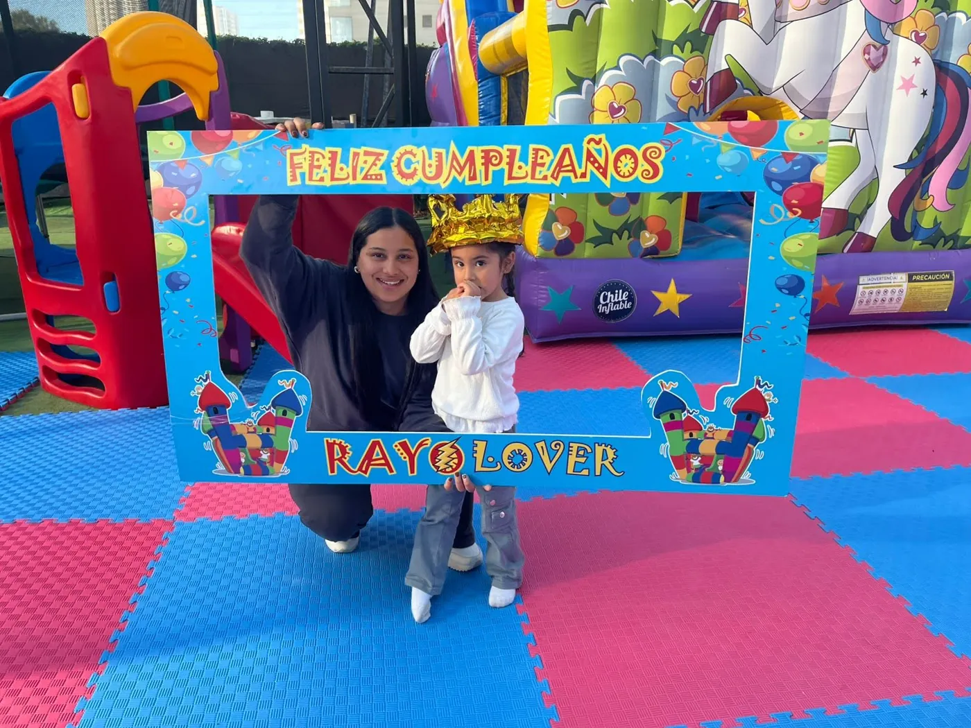 Mamá e hija posando con el marco Feliz Cumpleaños Rayo Lover
